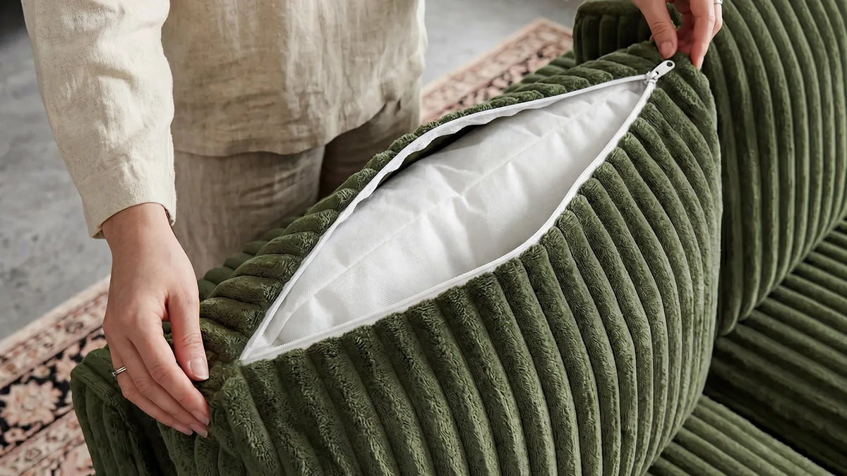 Person unzipping a washable sofa cover to show the removable cushion insert