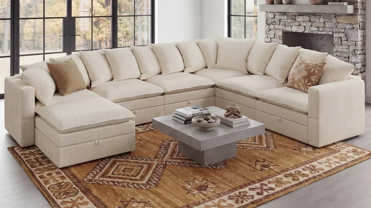 Beige L-shaped sleeper sectional with chaise in a bright living room, shown in closed seating position