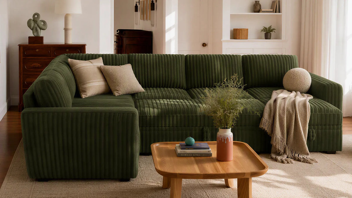 Green corduroy sectional sofa in a warm living room with wooden coffee table